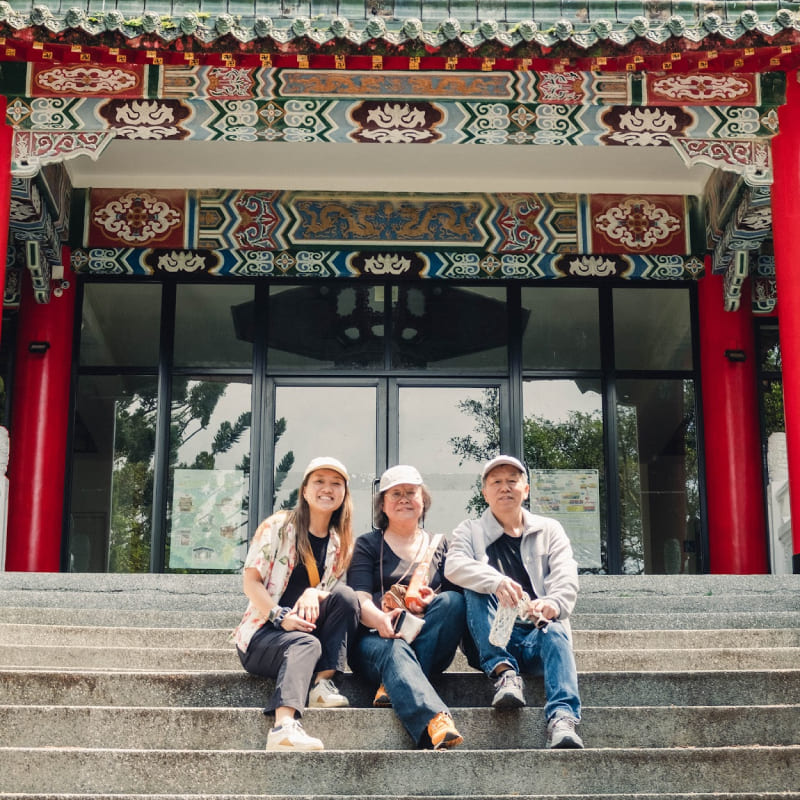 a woman and her parents in front of a Taiwanese temple