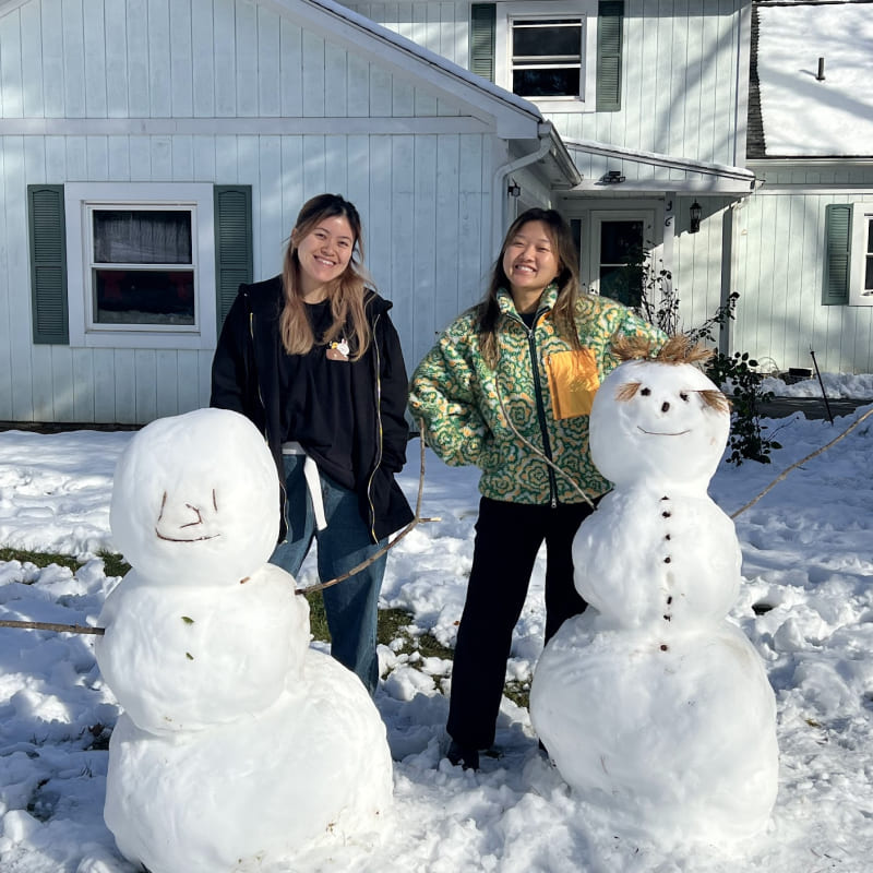 Two girls with two snowmen