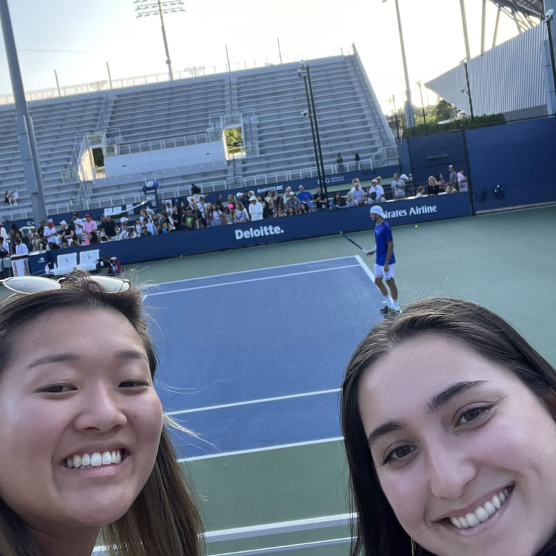 a selfie with a tennis court in the background