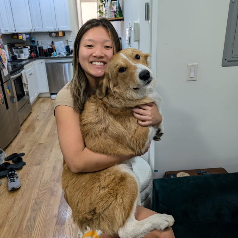 Cindy holding a large dog in her apartment