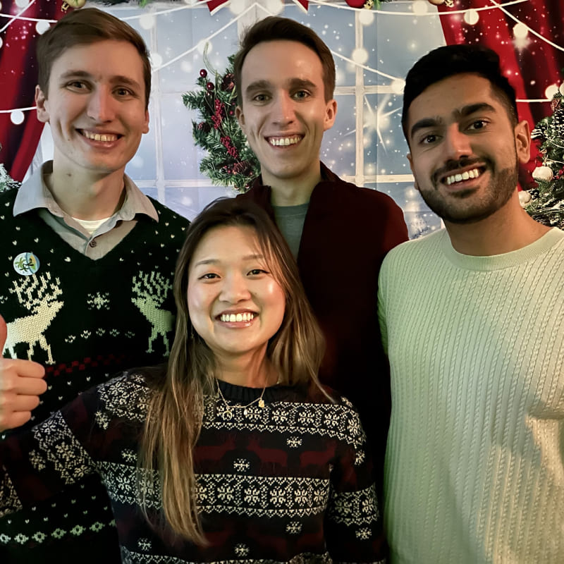 Four people in front of a snowy backdrop