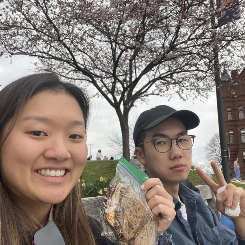 Cindy holding some sandwiches in a ziploc bag with Hansen making a peace sign